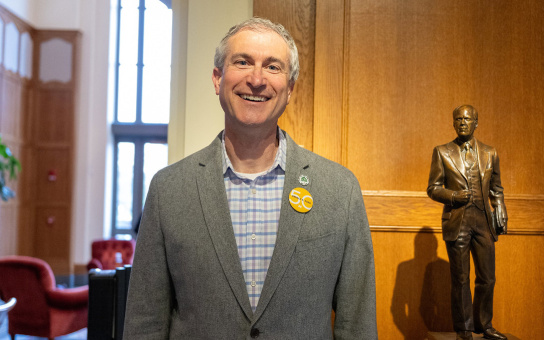 Christopher Taylor, Mayor of Ann Arbor, wearing a Ford50 button at Weill Hall, standing next to our statue of Gerald R. Ford