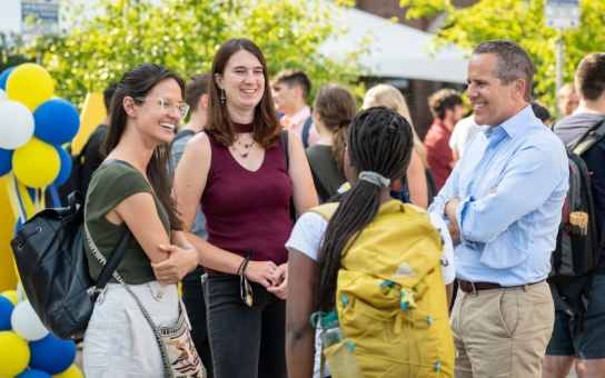 Dean Barr and group of master's students in conversation, outdoors in the parking lot behind Weill Hall, during the Ford School Fall Launch in 2021
