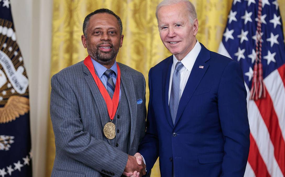 Earl Lewis receiving the National Humanities medal and shaking hands with President Joe Biden