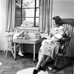 Betty Ford holds second son Jack while eldest son Michael plays.