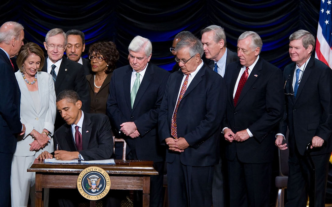 Politicians gather around President Obama as he signs the Dodd Frank Act