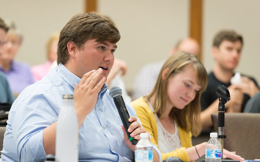 Jackson Voss asks a question of a visiting speaker