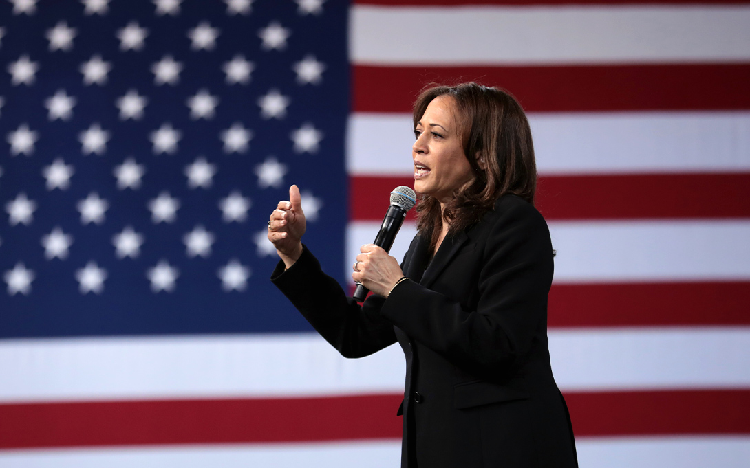 Kamala Harris speaking. An american flag in the background.