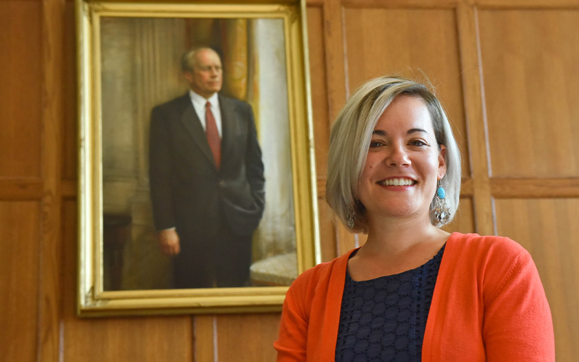Megan Nestor stands in Weill Hall in the shadow of a portrait of President Gerald R. Ford