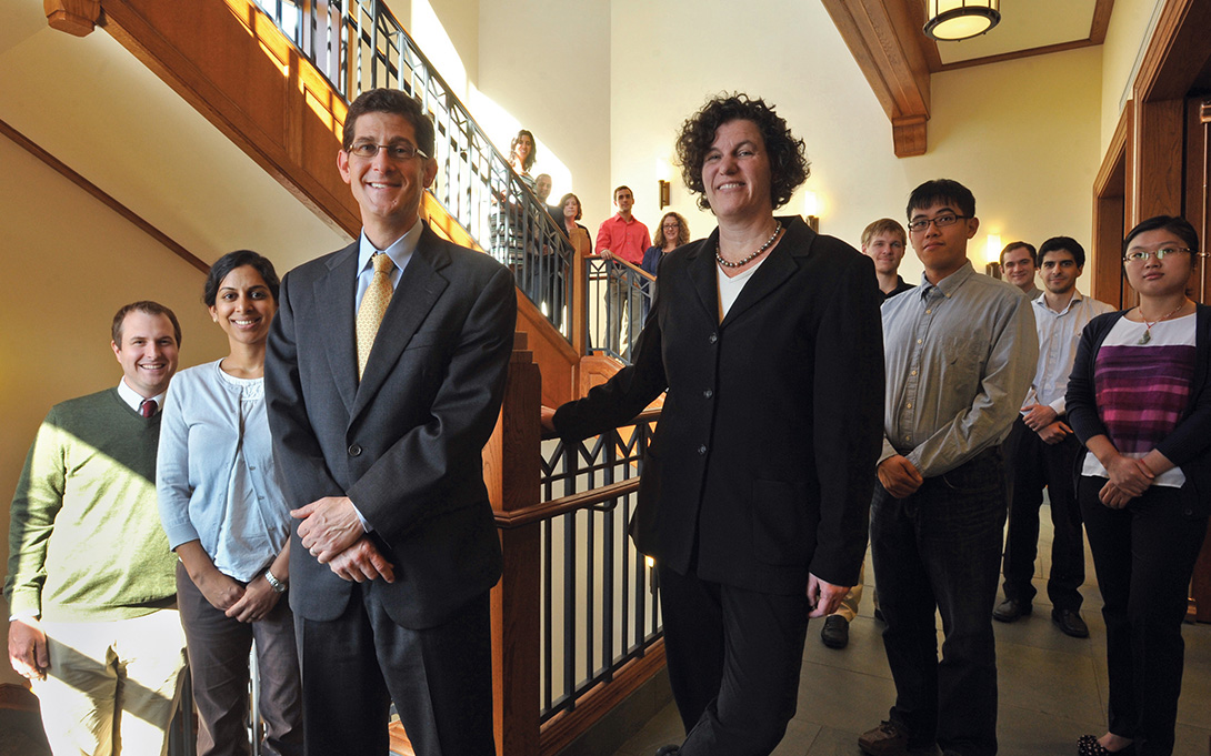 Brian Jacob, Sue Dynarski, and members of the Education Policy Initiative stand along the winding main staircase of the Ford School's home, Weill Hall