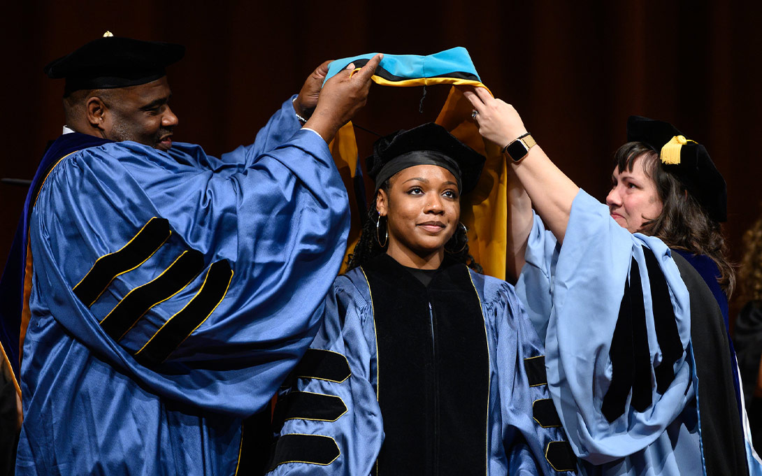 PhD student getting hooded at commencement