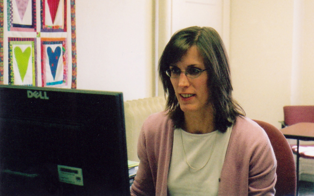 Photo of Kristin Seefeldt seated and working at a computer in her office