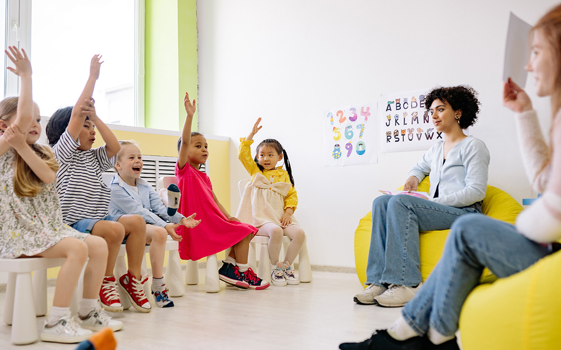 Photo of young children and their teachers in a classroom. By Yan Krukov