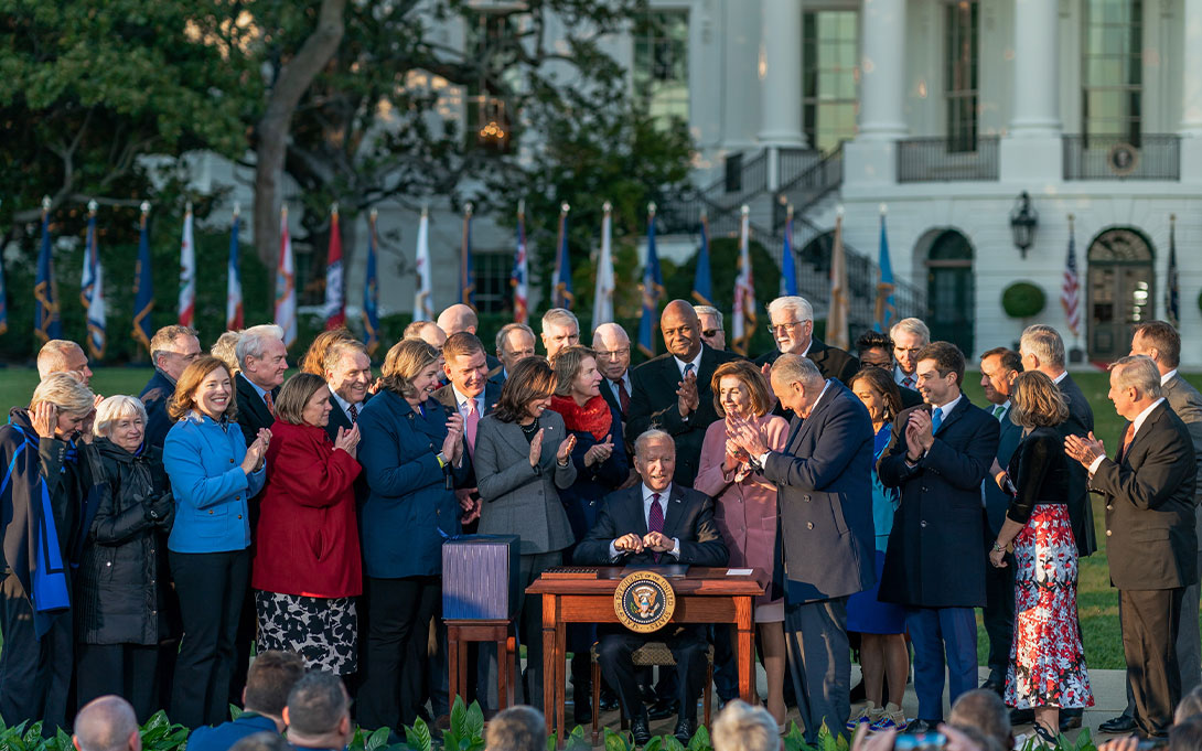 Fellow members of Congress and the Cabinet celebrating President Biden's signing of the bipartisan infrastructure deal