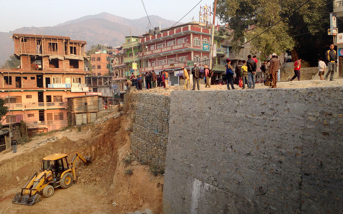Photo of the aftermath of an earthquake in Nepal and the rebuilding of a large retaining wall