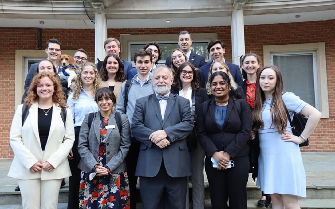 A group of Ford School students, with faculty and hosts standing in front of a building