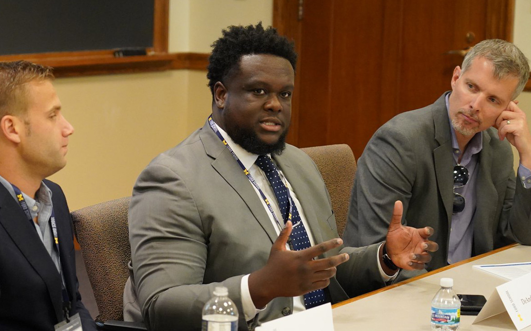 Photo of DeAndré Calvert addressing a room of attendees at the Ford School reunion in 2019