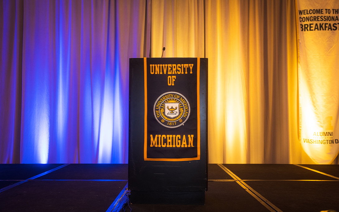 Photo of an empty podium featuring the U-M seal on stage at the 2022 Congressional Breakfast