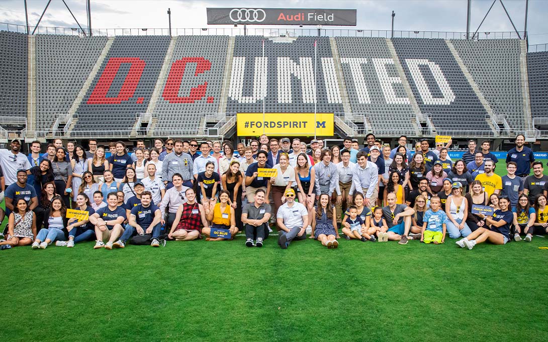 Photo of a large group of attendees at Worldwide Ford School Spirit Day in Washington D.C. at Audi Field, with stadium stands behind them emblazoned with the DC United wordmark and Audi Field signage