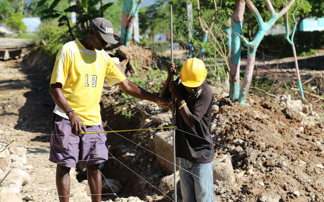 Photo of two Haitian men completing a construction job