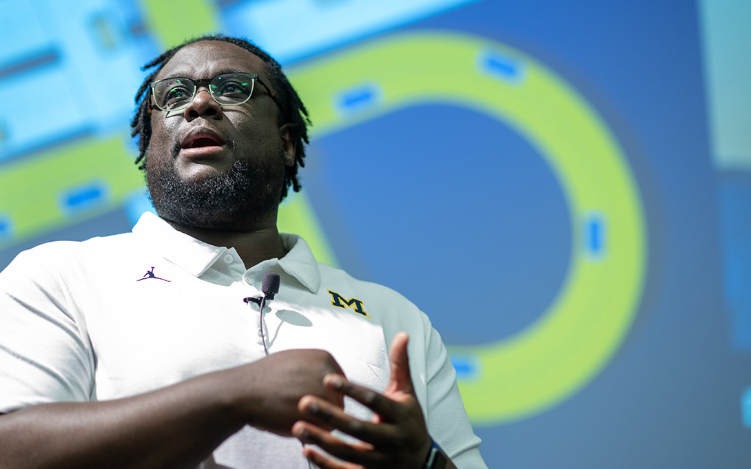 Photo of DeAndré Calvert addressing a room of attendees at the Ford School reunion in 2019