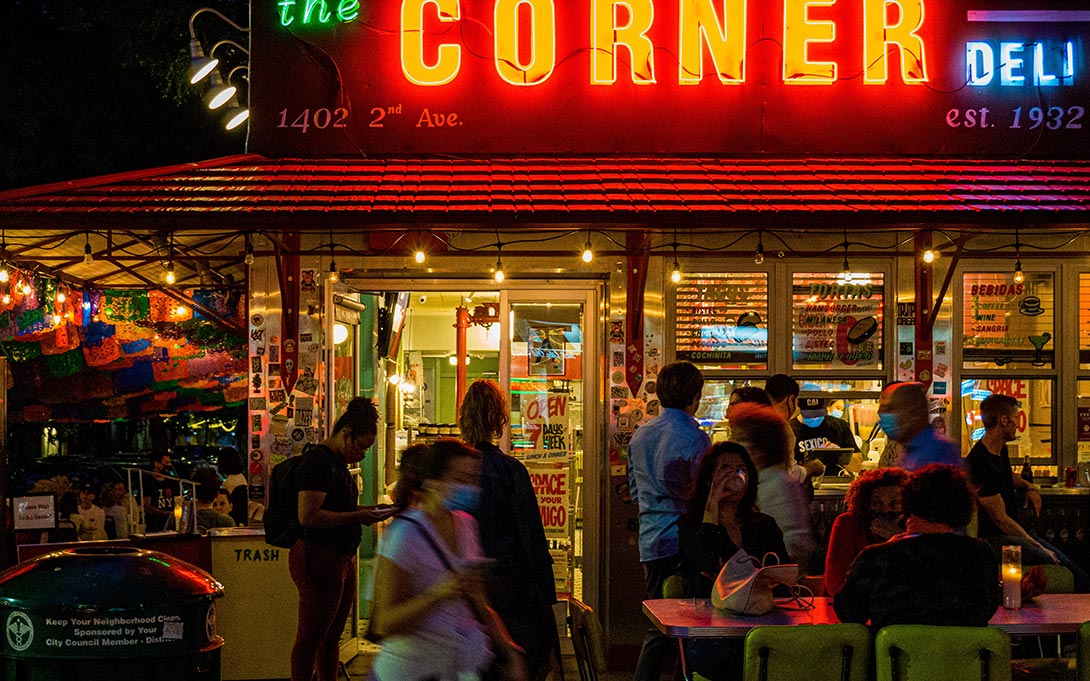 Photo of patrons outside a New York City corner deli