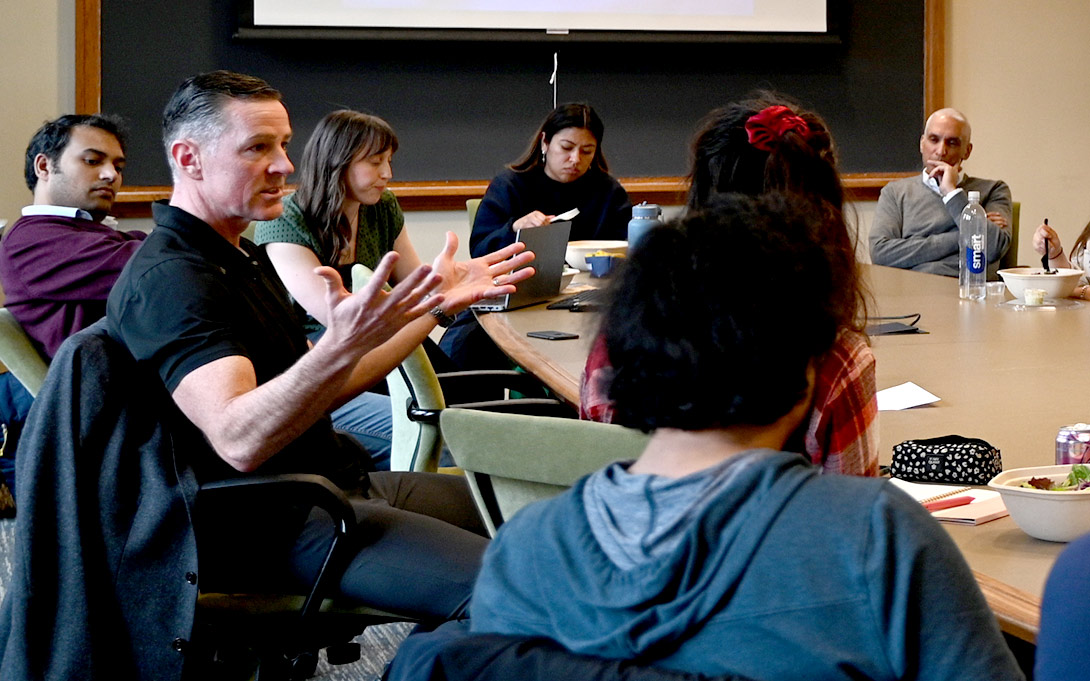 Matt Maasdam sits with Ford School students during a leadership luncheon.