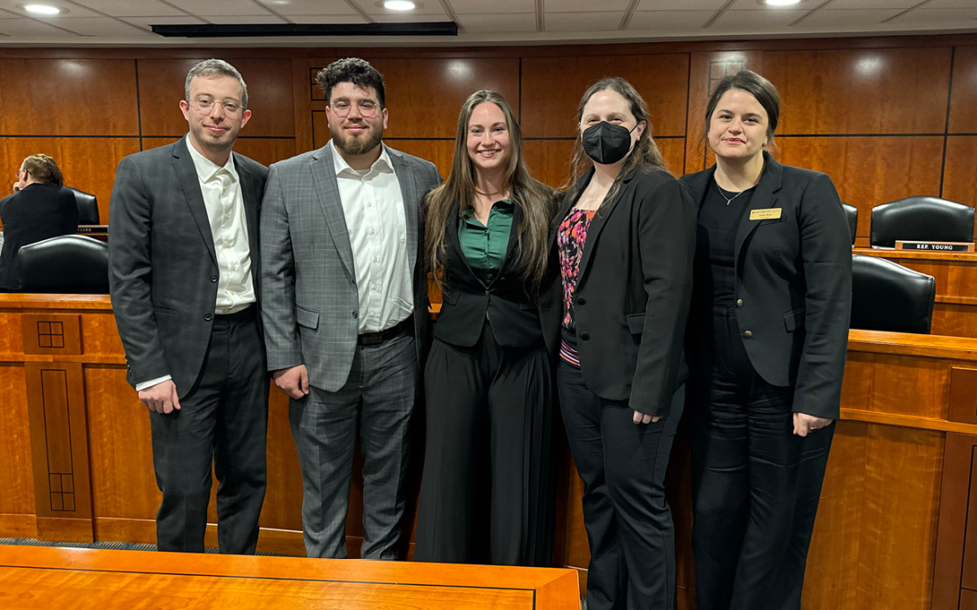 Students standing in a courtroom after a public briefing