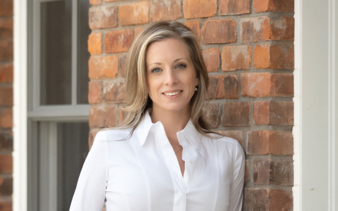 Headshot of Jessica Morschakov, posed in front of an exterior brick wall