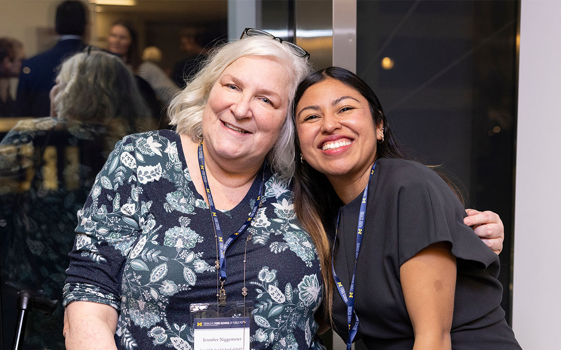 Two attendees smiling and posing together for a photo.