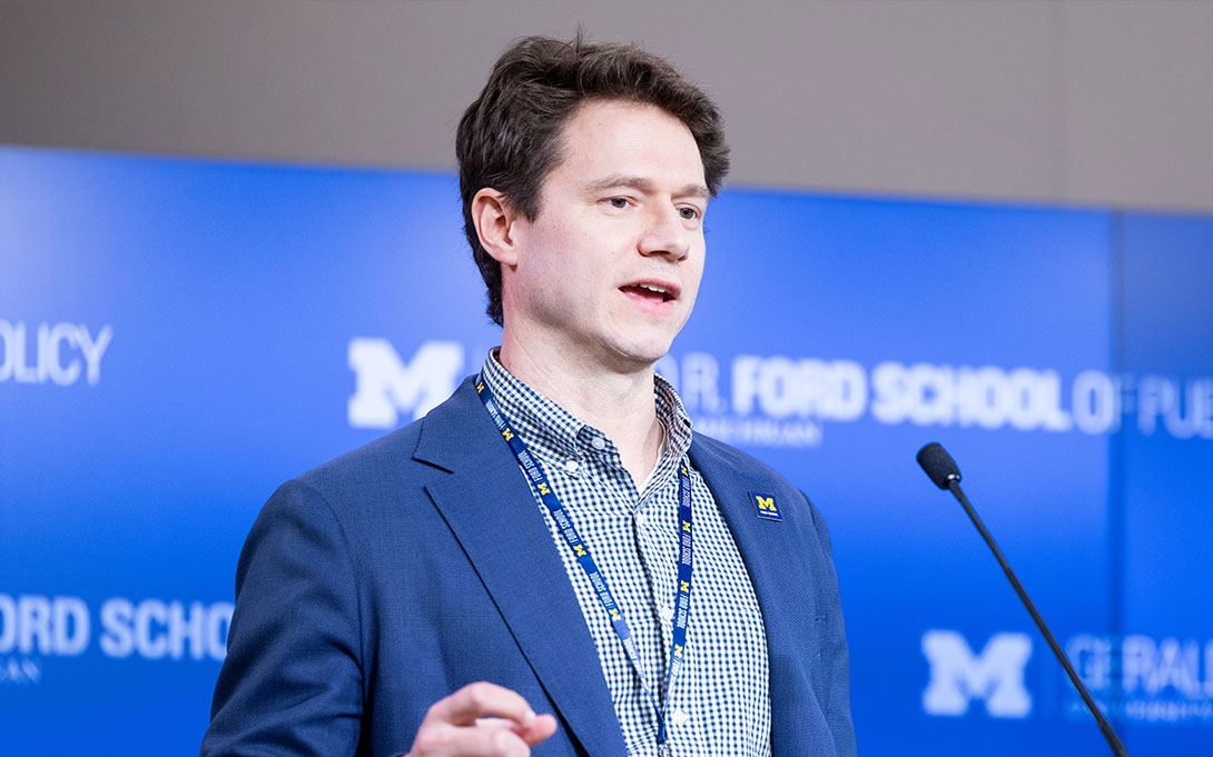 Person speaking at a podium with the University of Michigan and Gerald R. Ford School of Public Policy logos in the background.