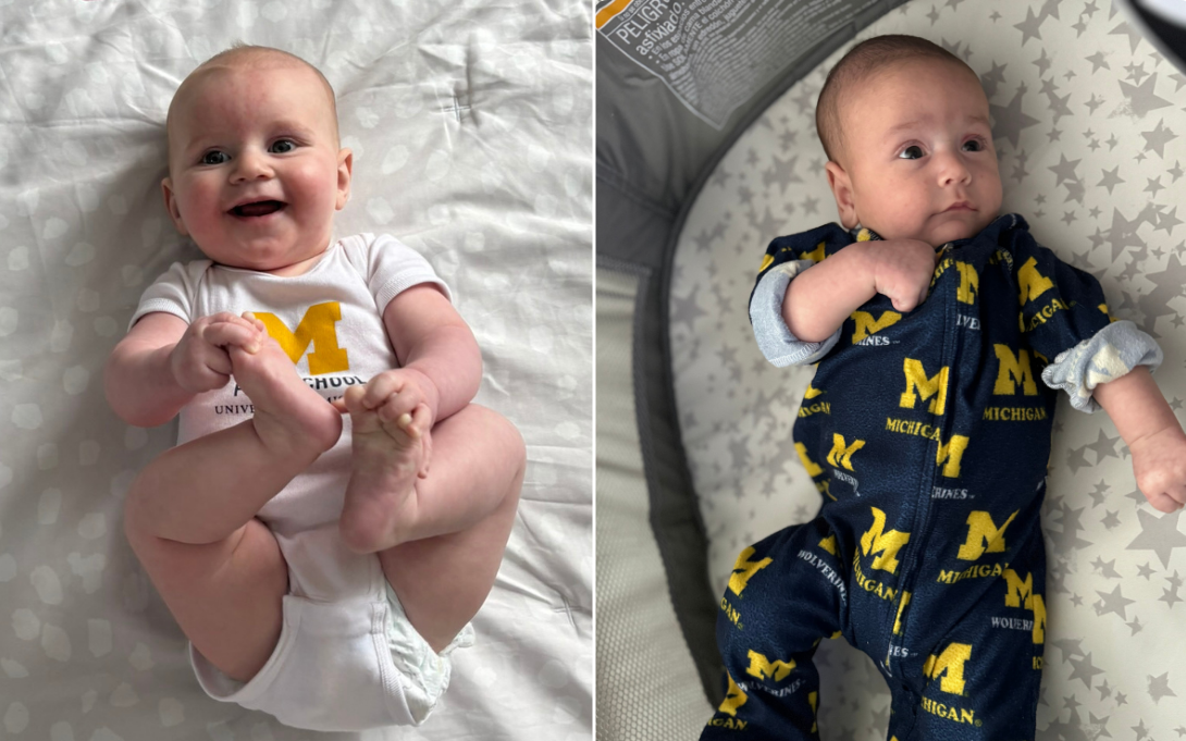 Two infants wearing University of Michigan outfits; one lying on a star-patterned blanket smiling, and the other resting against a pillow looking thoughtful.
