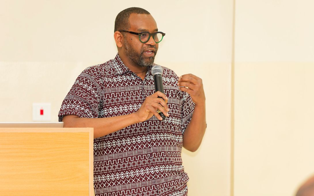 Yousif Hassan speaking at a podium