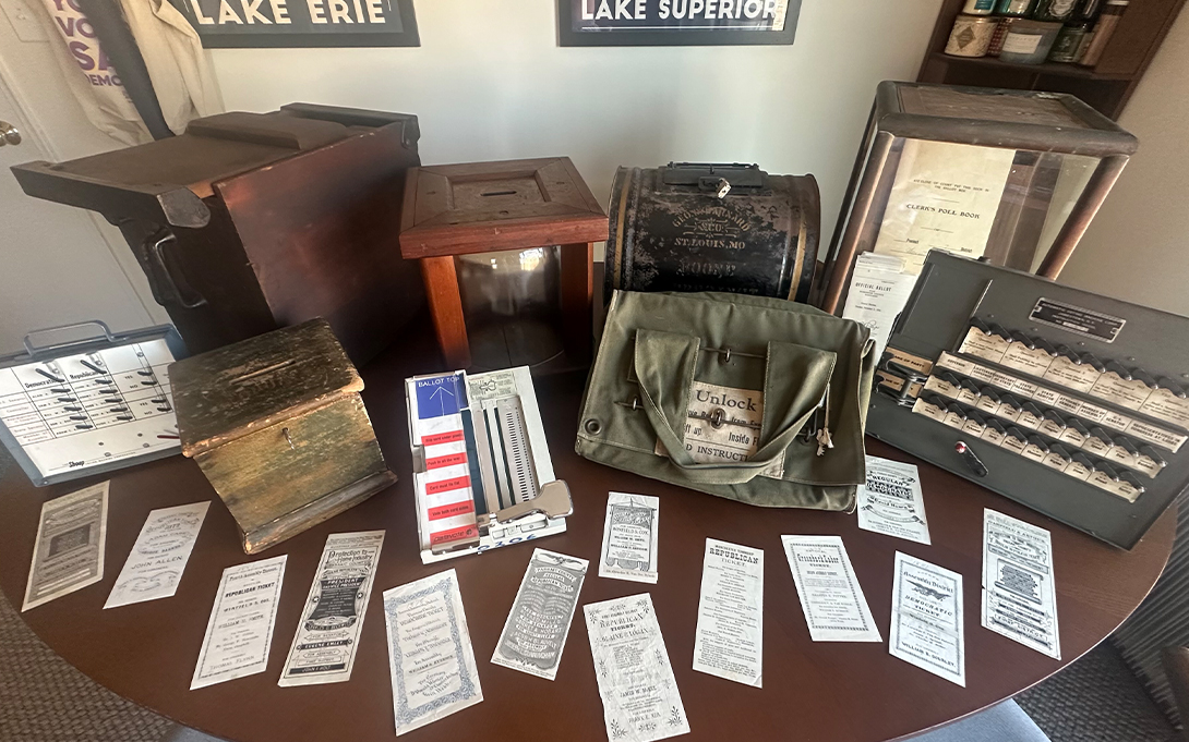 A collection of vintage voting ballots, boxes, and other accessories.