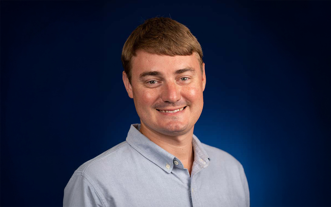 Headshot of Sam Stragand, background expanded with AI.