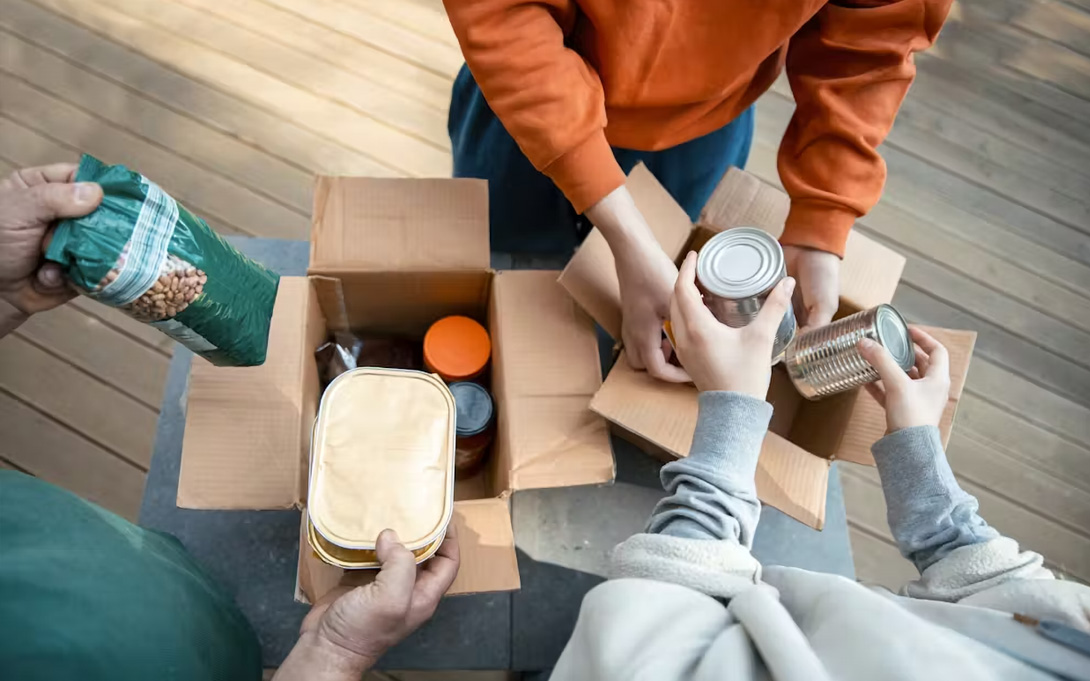 People packing food in donation boxes.