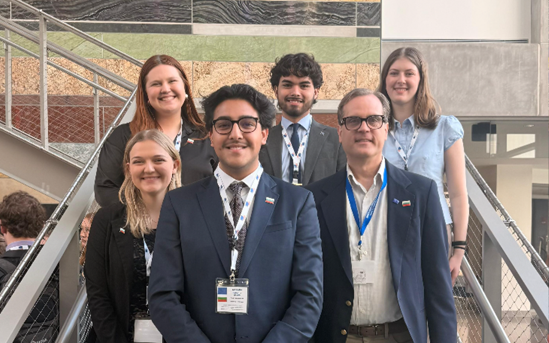 A group of smiling people gathered on a stairwell for a group photo