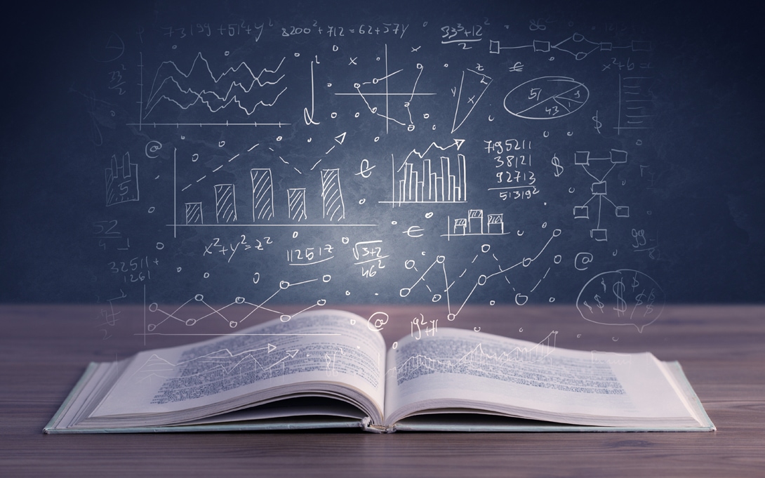 Open book laying on table with doodles, sketches, and graphs above it