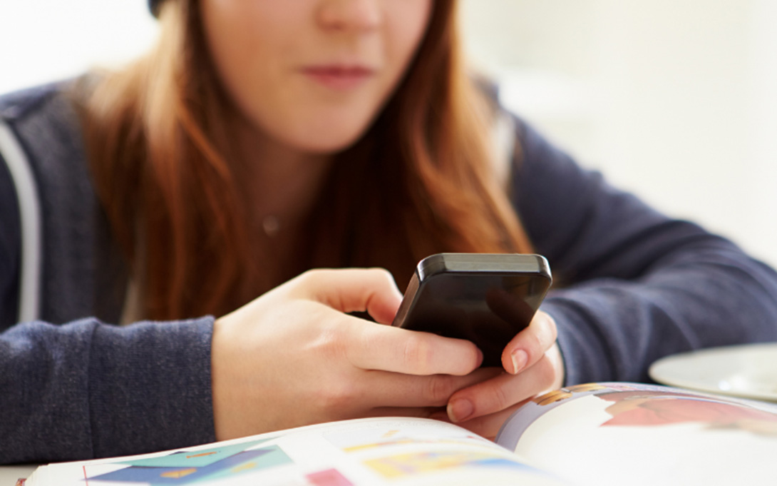 girl using a call phone while studying