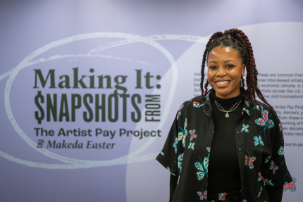 Makeda Easter standing in front of a sign that says making it: snapshots from the artist pay project