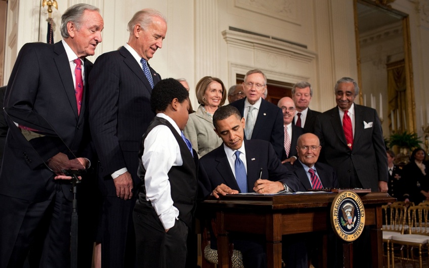 President Obama signs the Affordable Care Act with a crowd of stakeholders