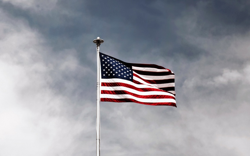 Photo of an American flag backed by a gray sky