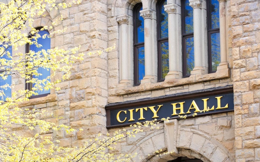 Photo of a stone building with a large "City Hall" sign