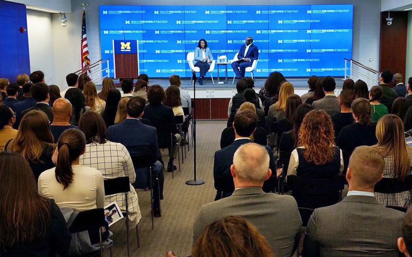 Dean Celeste Watkins-Hayes and Hardy Vieux (MPP/JD ‘97) on stage in front of an audience of Ford School students, alumni, and friends in DC