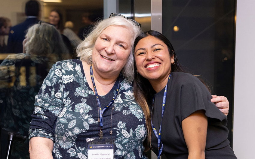 Two attendees smiling and posing together for a photo.