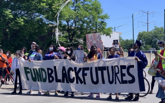 Rally participants hold a banner that says "Fund Black Futures"