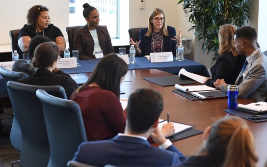 Photo of students and U-M alumni gathered around a conference table