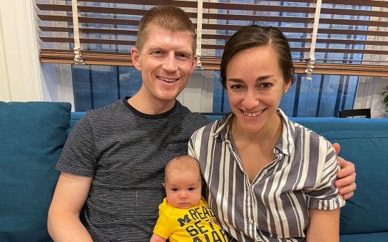 Photo of Andrew Bracken, his spouse Rachel, and their child Adelina Johansen Bracken