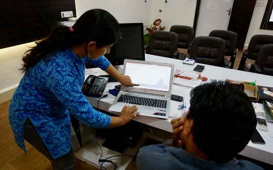 Photo of two people  at a computer