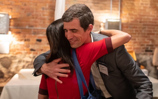 Friends and Bohnett alumni Stephanie Chang and Andrew DeLeeuw greeting each other with a hug