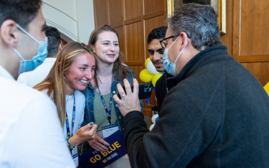 A group of alumni chat in the Great Hall