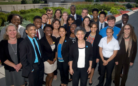 Group of diverse individuals posing outdoors in a semi-formal setting.