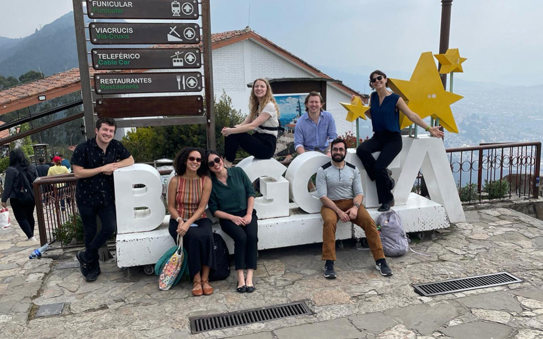 Students smiling next to a Bogota sign in Colombia