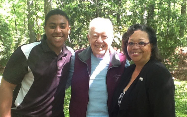 Photo of President Carter with Ambassador Page and her son outside on a sunny day