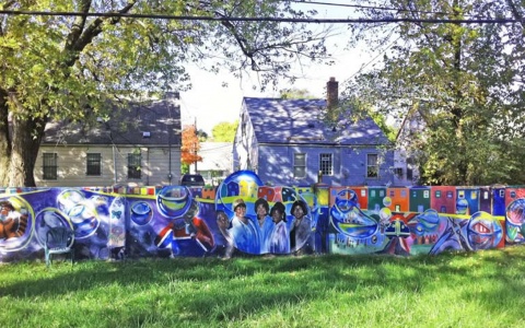 Among the houses in this residential neighborhood, a wall wall erected to segregate by race has been reclaimed and turned into a large community art project.
